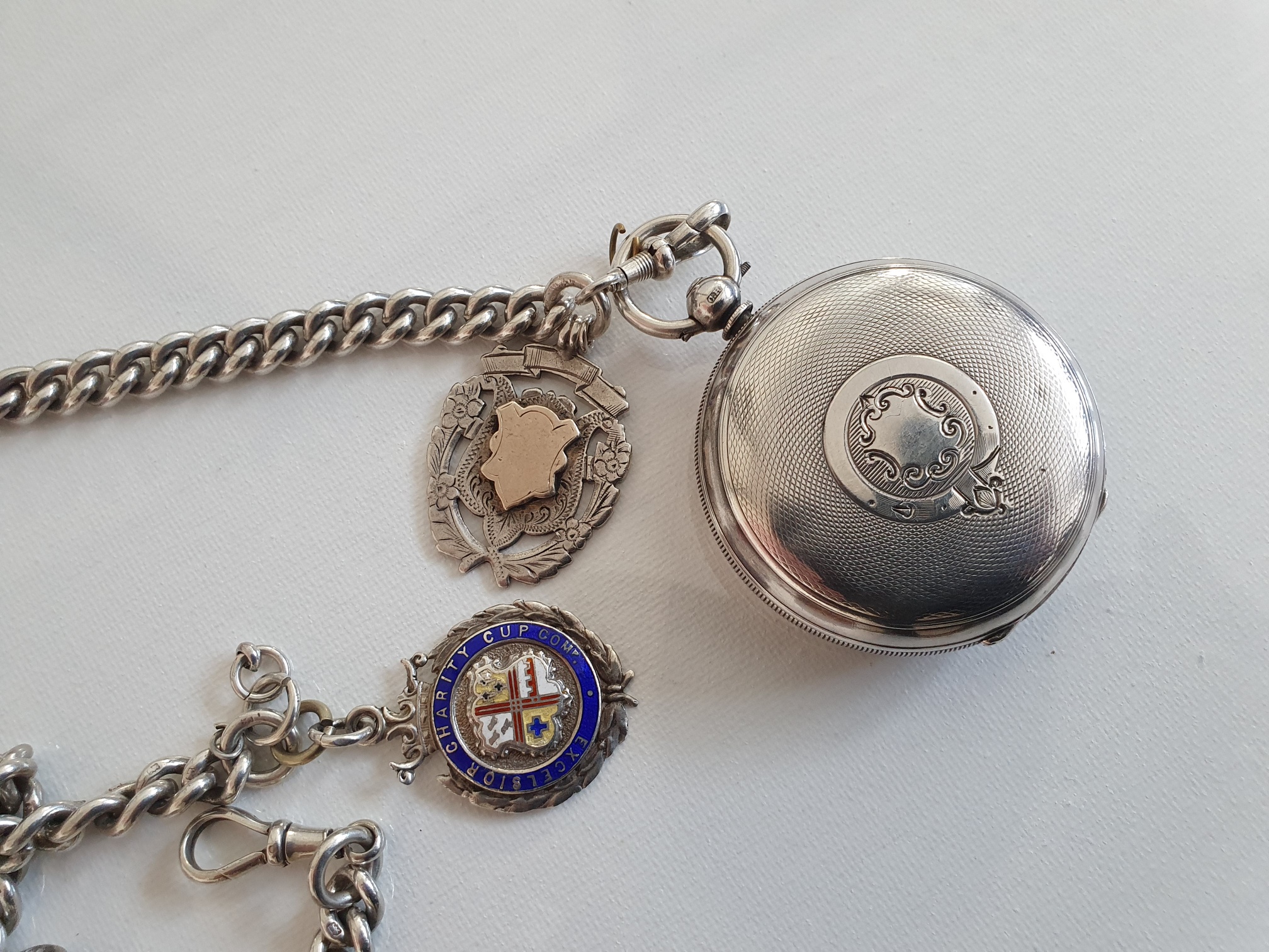 Solid silver pocket watch with chain and fob.
